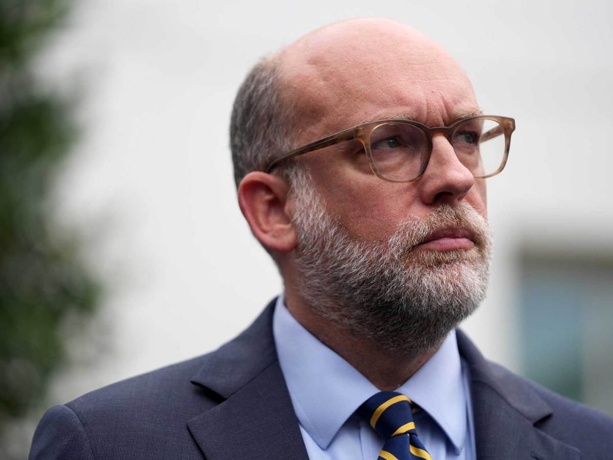 A photo of a man with a grey beard and glasses