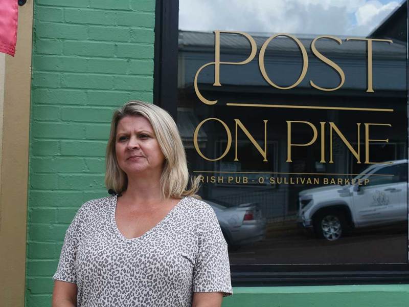 Woman stands in front of a building during an interview.