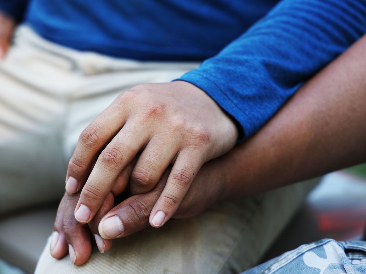 A closeup of two men’s hands clasped together