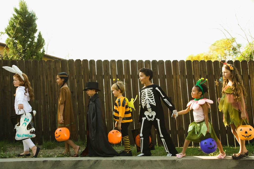 A diverse group of children dressed in various Halloween costumes.