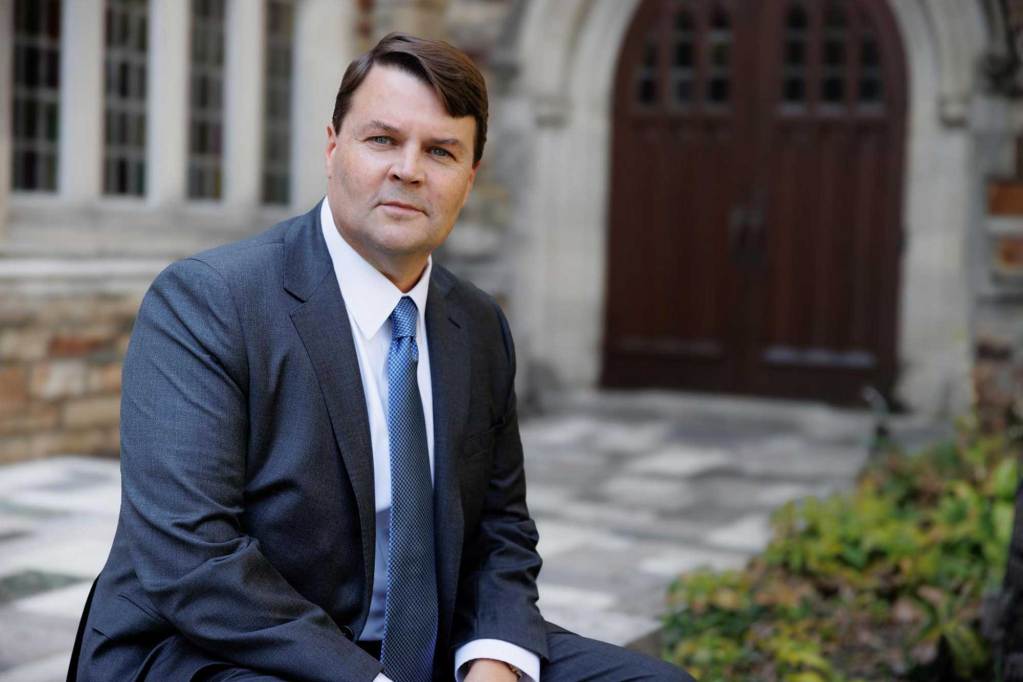A portrait of Cliff Johnson sitting outside of a church building