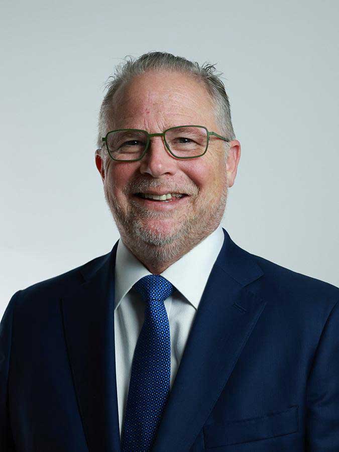 Official headshot of Craig Gundersen in a navy suit