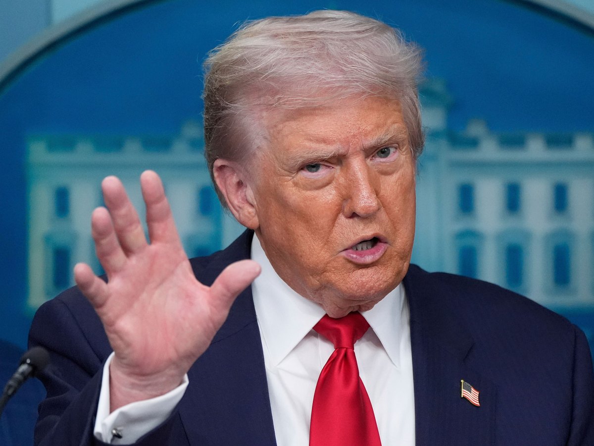 Donald Trump speaks in a press conference, hand gesturing wide