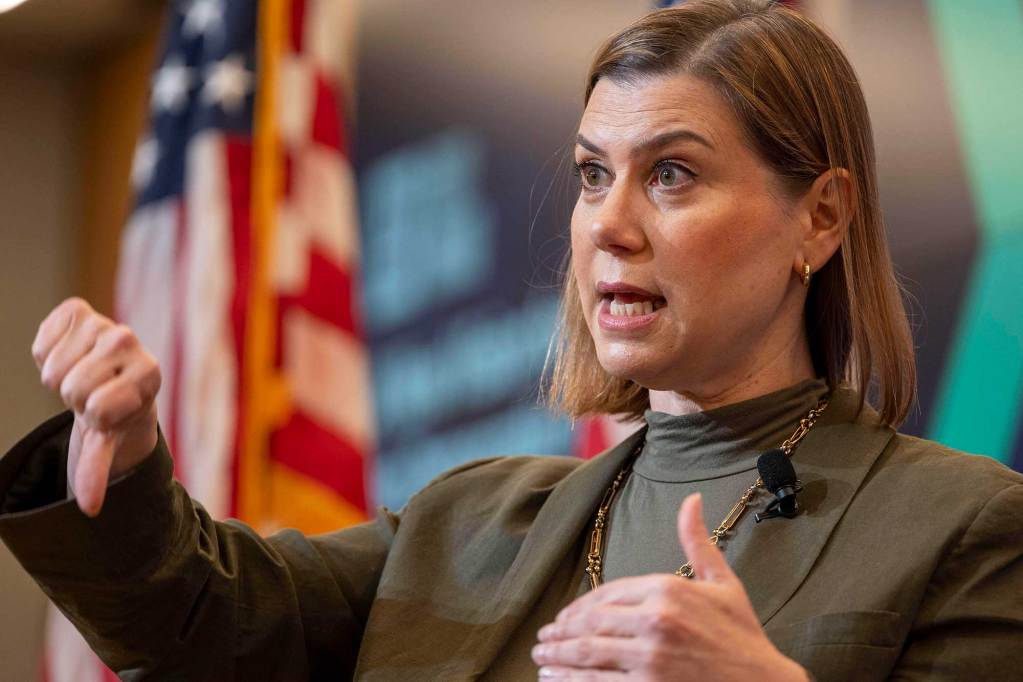 Elissa Slotkin gestures with both hands as she speaks on stage for an event