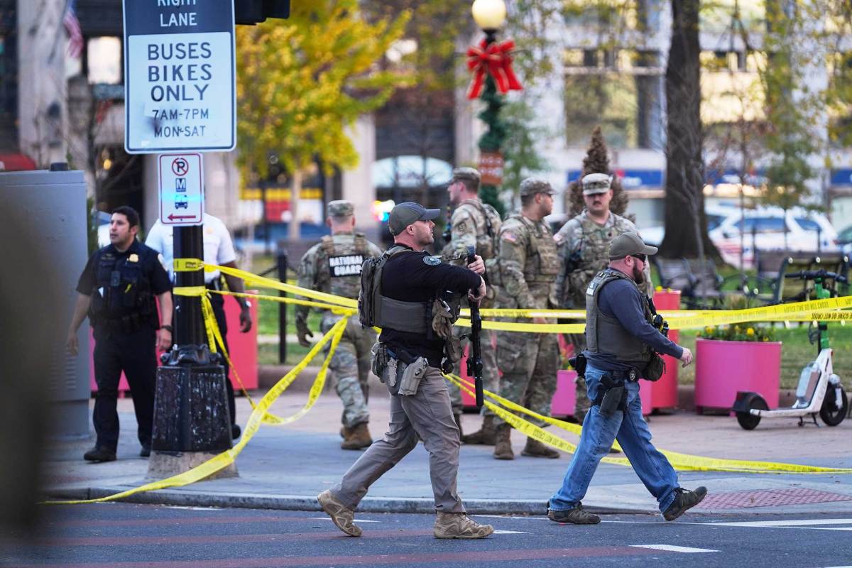U.S. Marshalls and National Guard troops are seen walking around an area cordoned off with yellow tape