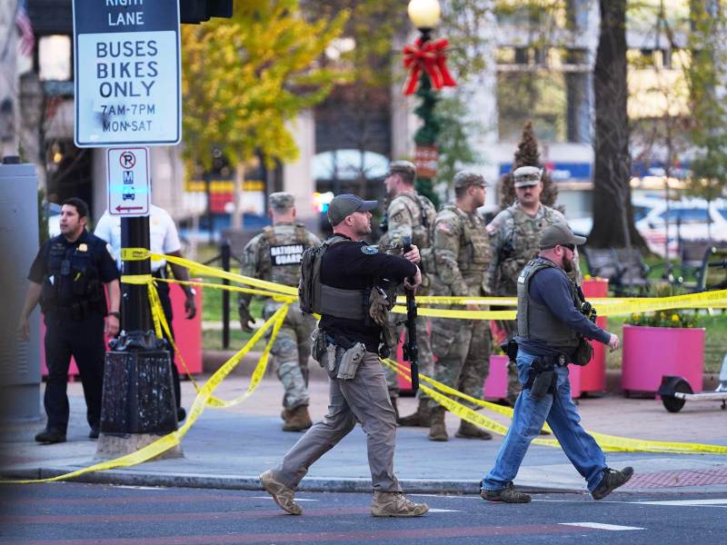 U.S. Marshalls and National Guard troops are seen walking around an area cordoned off with yellow tape