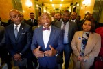 A group of mostly black lawmakers, with one man in the center speaking with his hands out