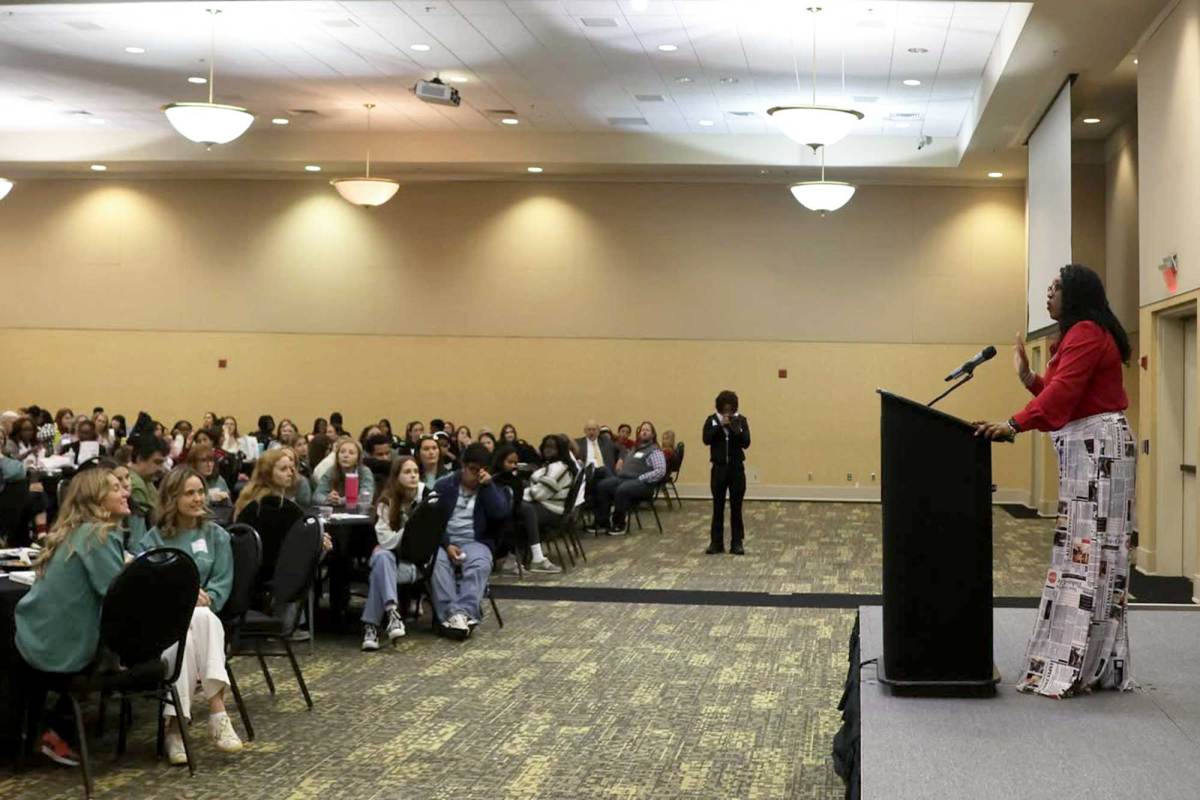 Torsheta Jackson standing on stage speaking to a packed audience