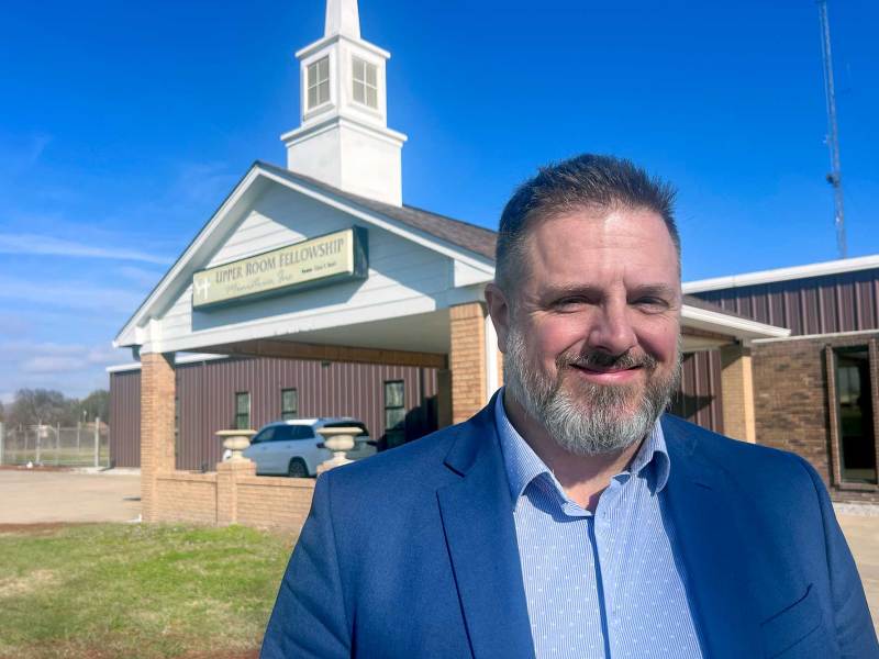 David Herndon stands outside of a church that also serves as a school