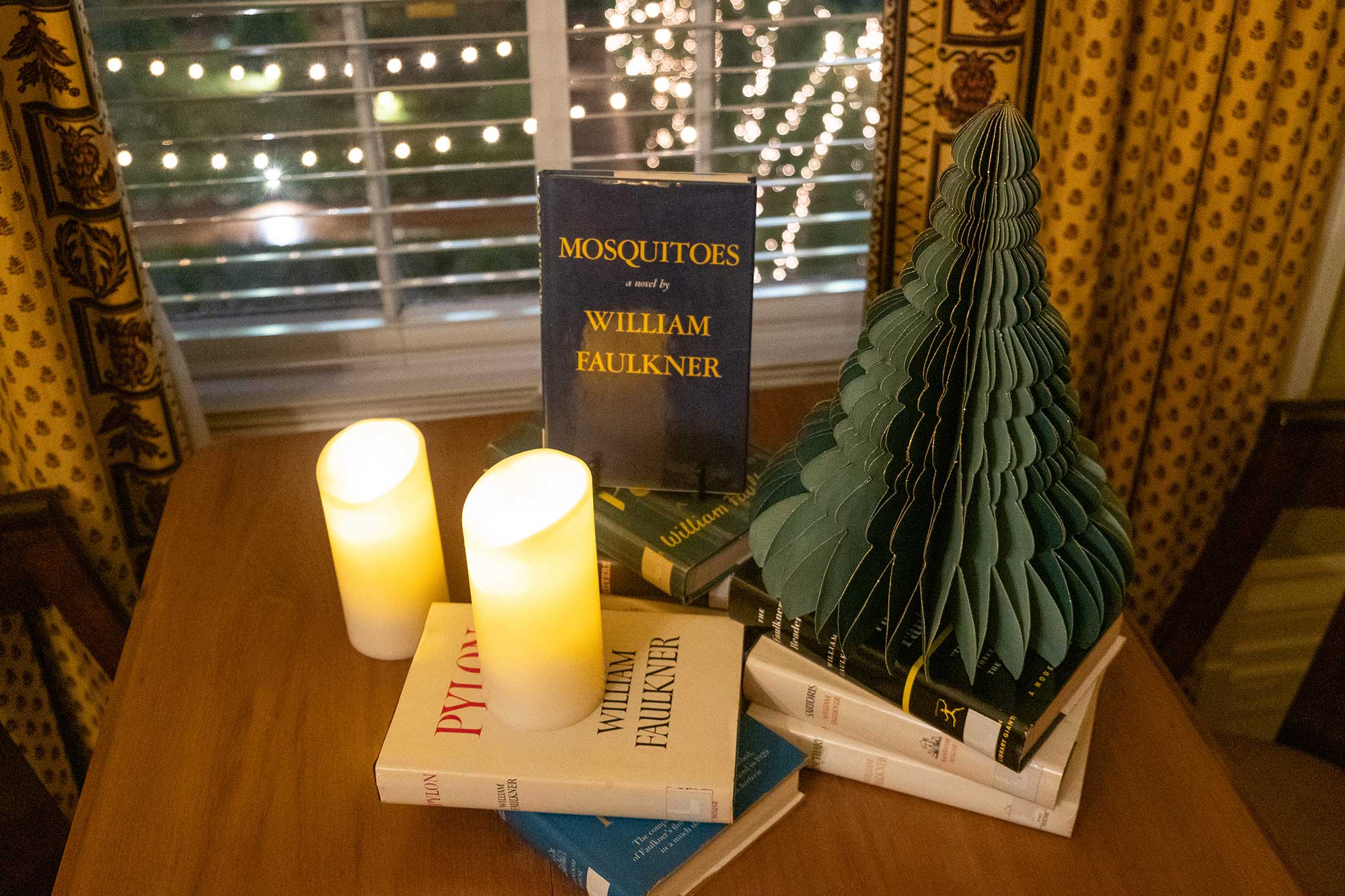 A table in the Governor's Mansion is covered in candles, green Christmas decorations and local Mississippi books