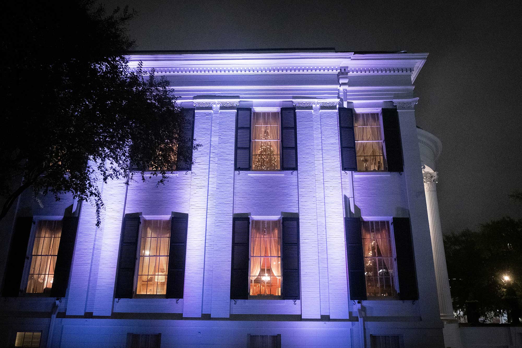 The side exterior of the Mississippi Governor's Mansion, with Christmas trees visible in the windows