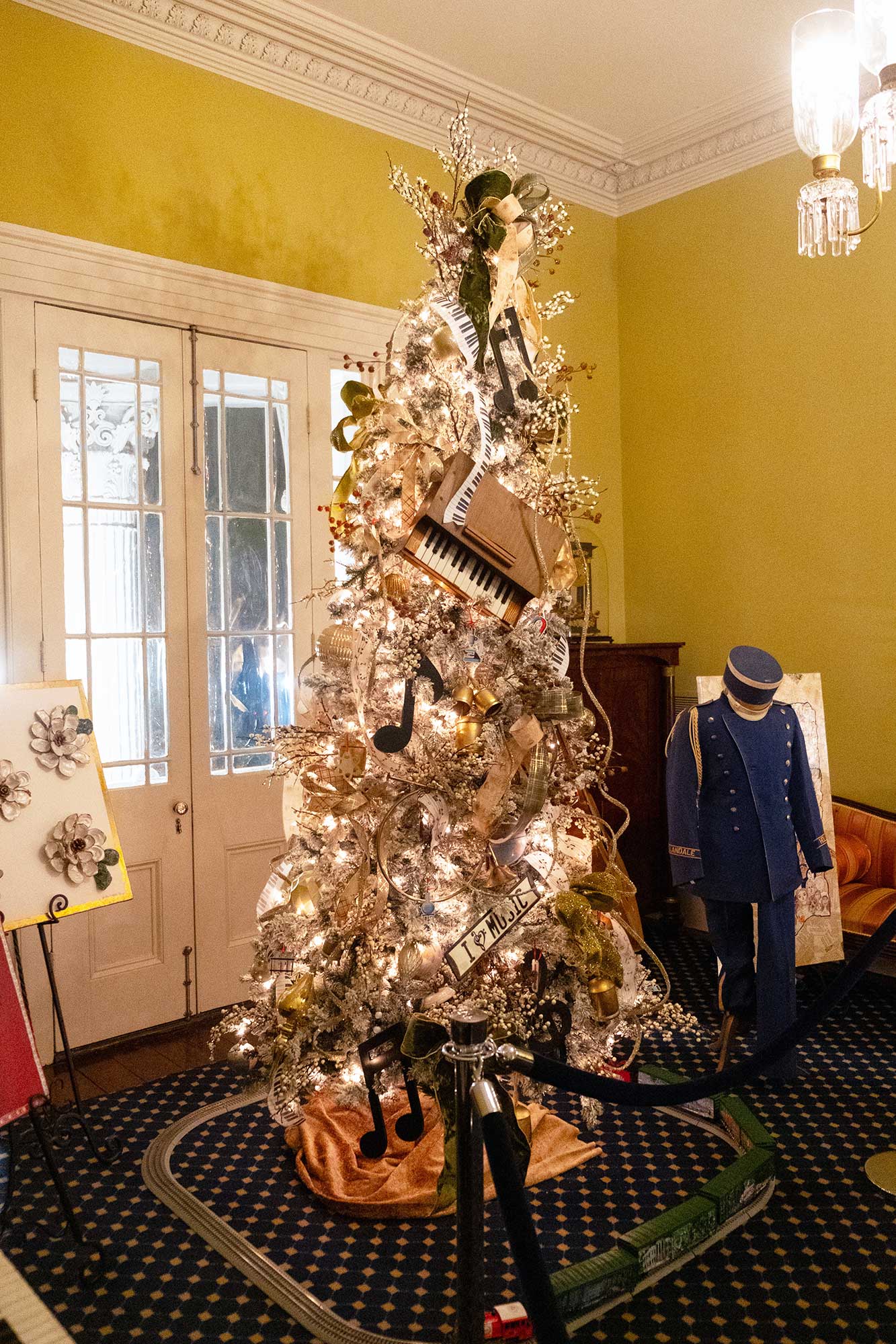 An interior view of the Mississippi Governor's Mansion, decorated for Christmas with a tree in a decorated in a musical theme