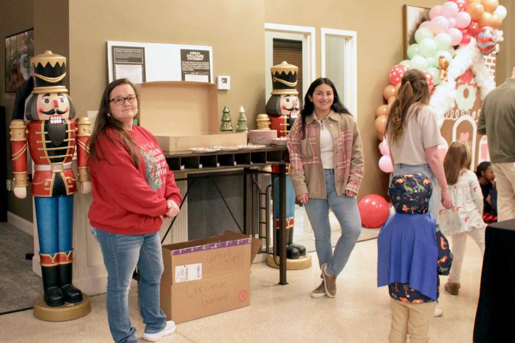 People stand inside beside life size holiday nutcrackers