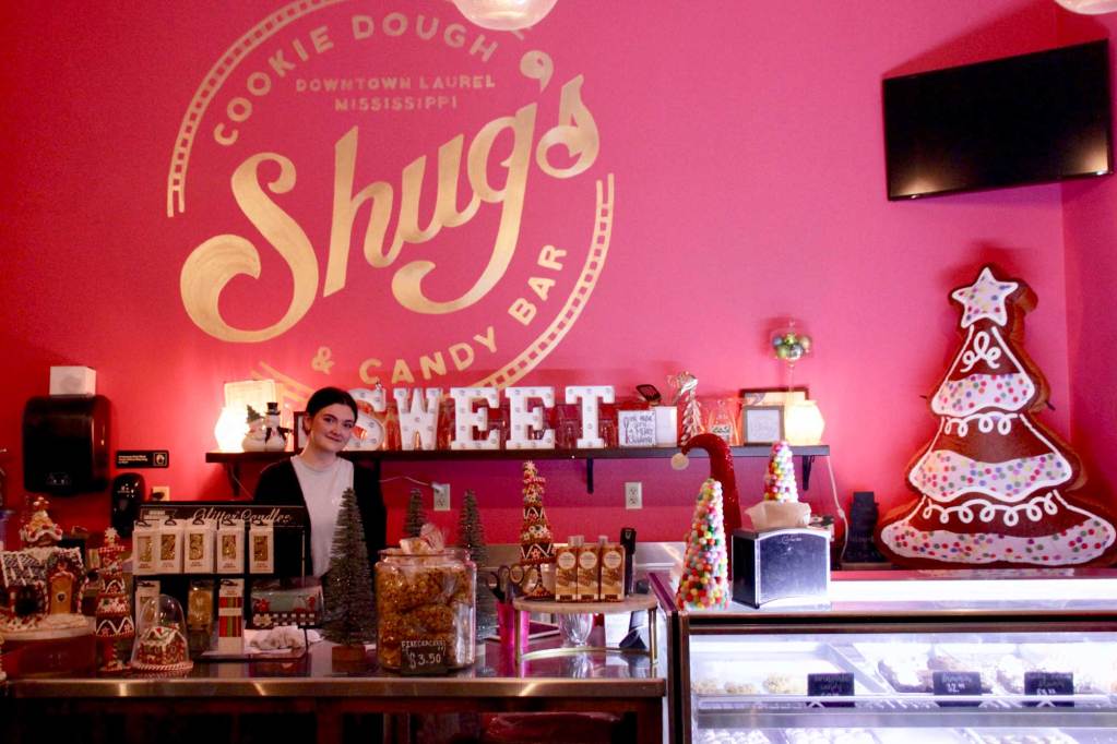 A person stands behind the counter at a sweet shop