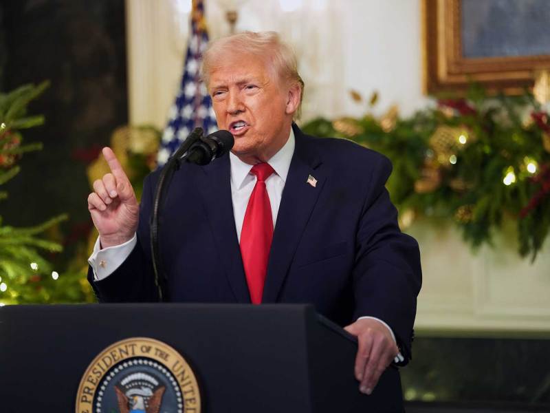 Donald Trump speaking at a podium in the White House