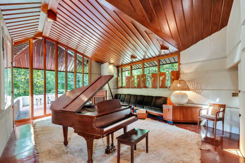 An interior view of the Fountainhead living room with vaulted wooden ceilings and floor to ceiling windows