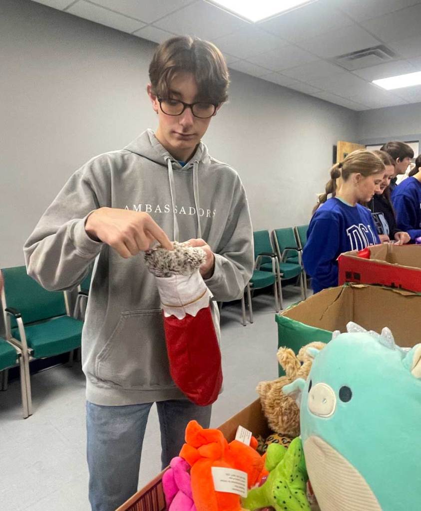 A person stuffs toys into stockings
