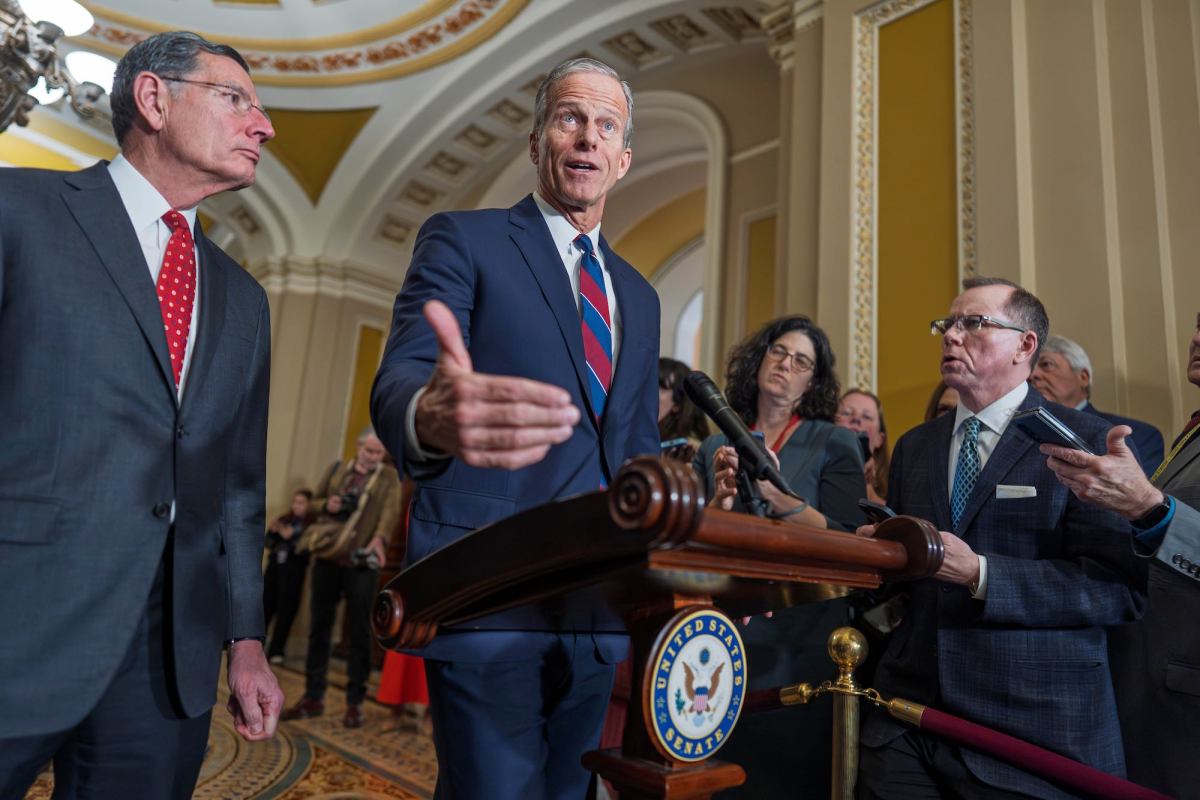 John Thune speaking at a podium in the Capitol building. John Barrasso is to his left.