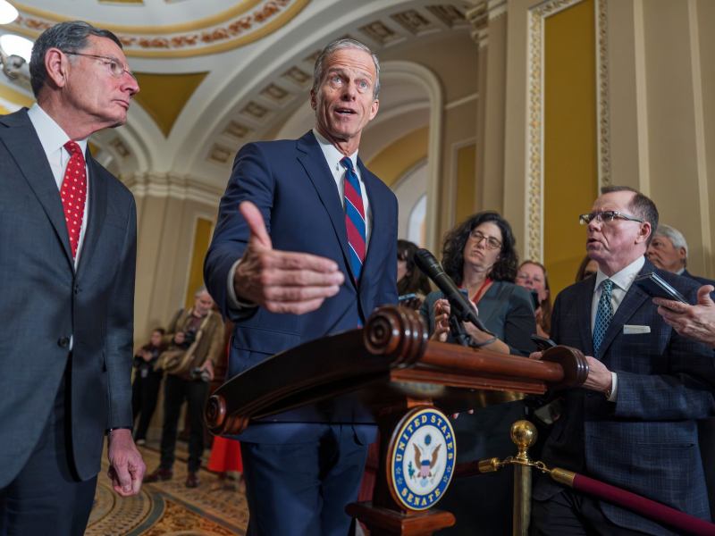 John Thune speaking at a podium in the Capitol building. John Barrasso is to his left.