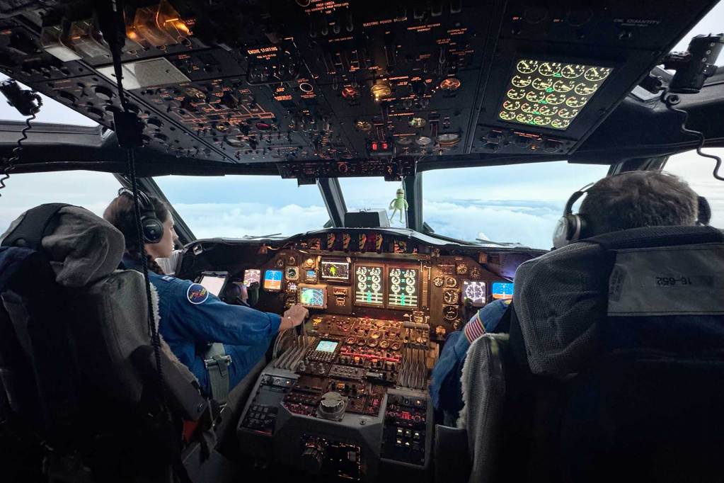 Two pilots sit in the cockpit and fly a plane