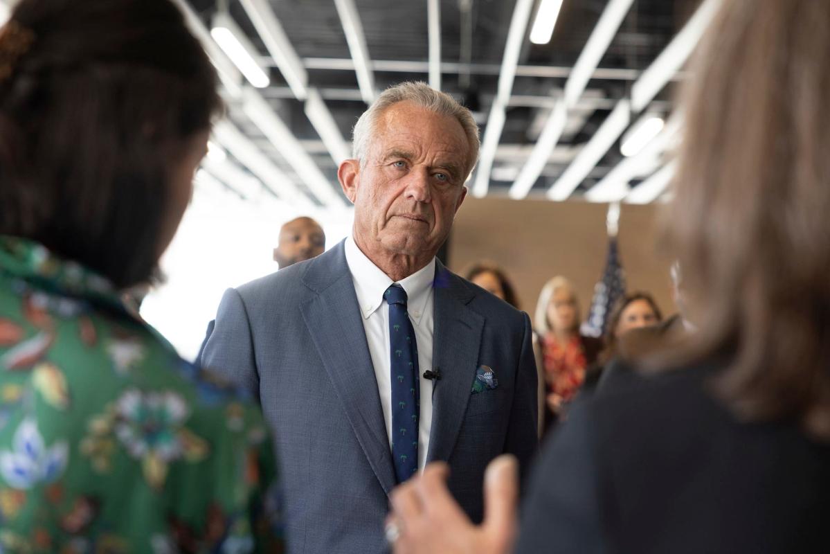 Robert F. Kennedy Jr.at an event, listening to people talk