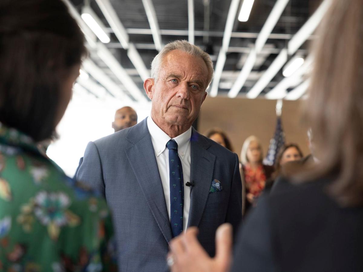Robert F. Kennedy Jr.at an event, listening to people talk