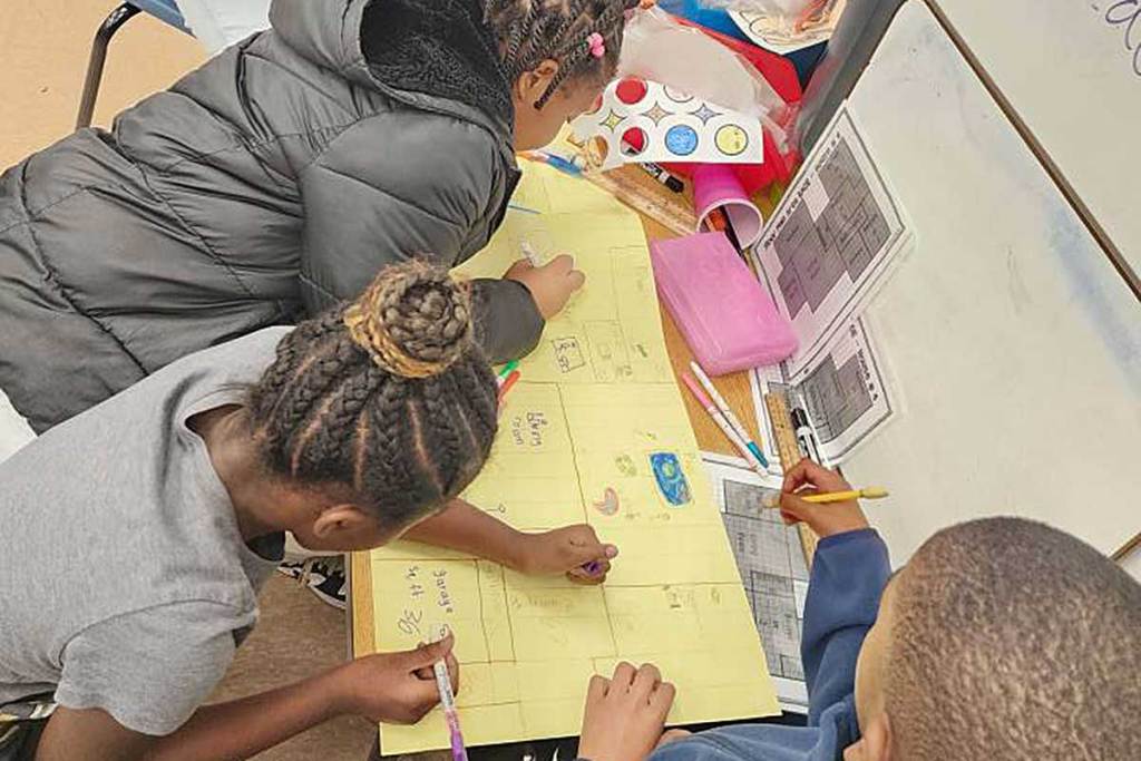 Three students draw basic floor plans of a building