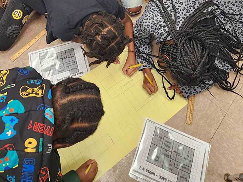 Three students draw basic floor plans of a building