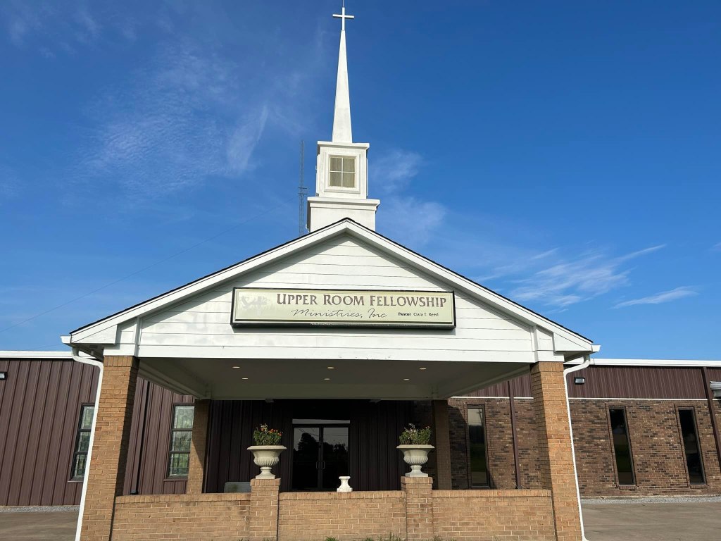 An exterior view of a church building labeled 'Upper Room Fellowship'