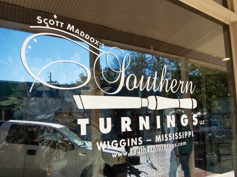 The Southern Turnings logo and name appear on a storefront window reflecting the street outside.
