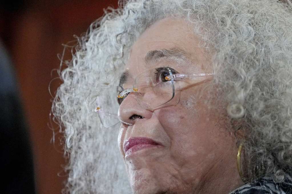 A close up of Angela Davis's face, framed by curly silver hair
