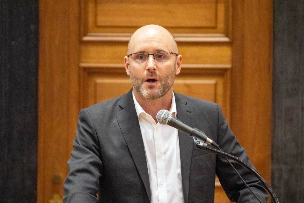 Trevor Millar speaks at a podium