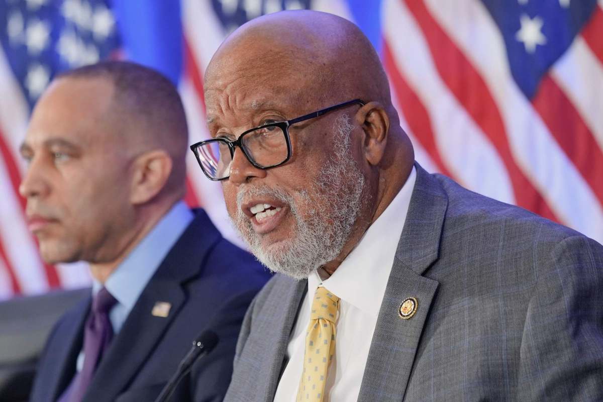 Bennie Thompson speaking at an event, US flags behind him