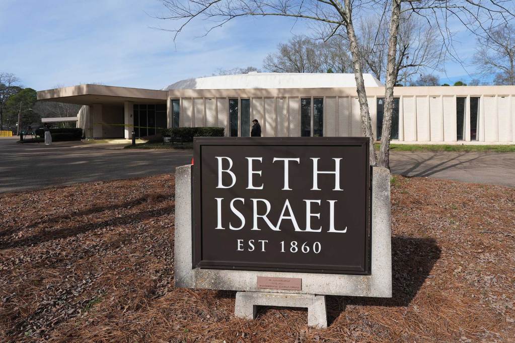 A sign that reads 'Beth Israel Est 1860' in front of the synagogue. A security person is walking by and the front door is wrapped in yellow caution tape