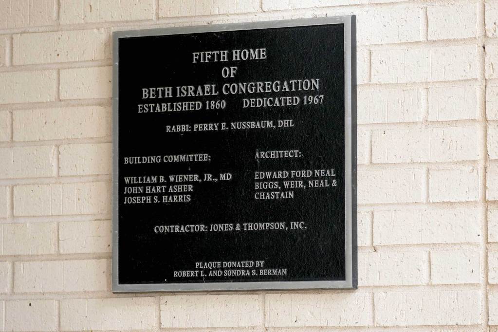 Plaque outside of a white brick building noting that this is the fifth home of the Beth Israel Congregation