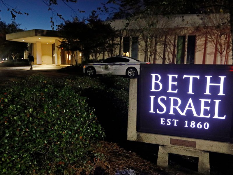The exterior of Beth Israel synagogue, with a sign saying it was established in 1860, with a local police car parked in front