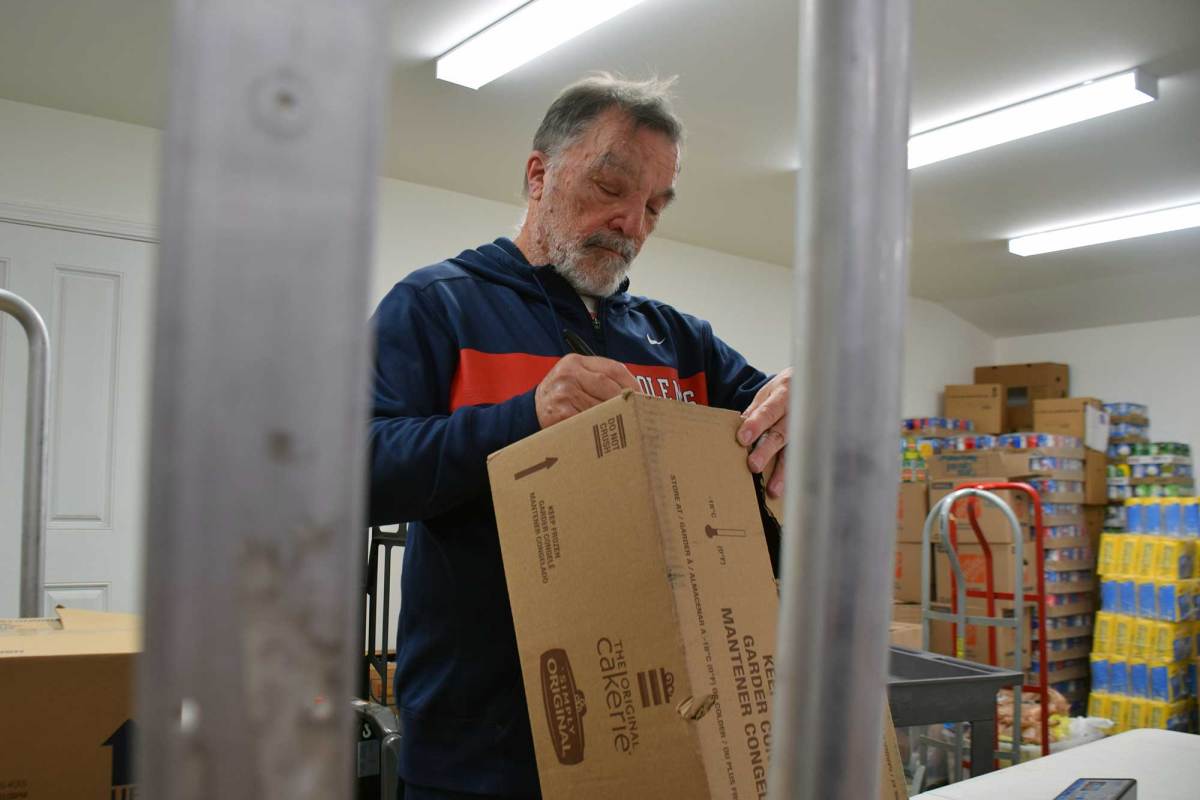 A man weighing boxes inside a pantry inventory room