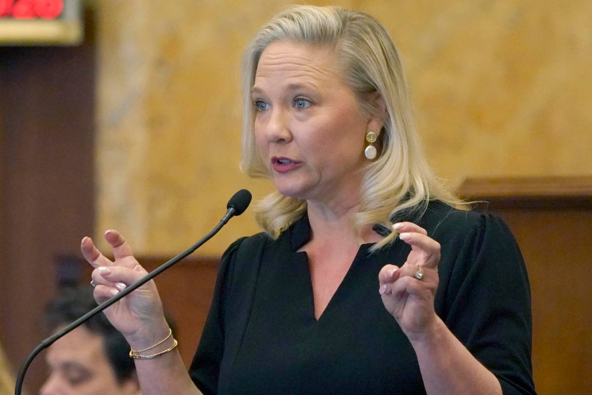 Celeste Hurst speaking at the mic, making air quotes with her hands