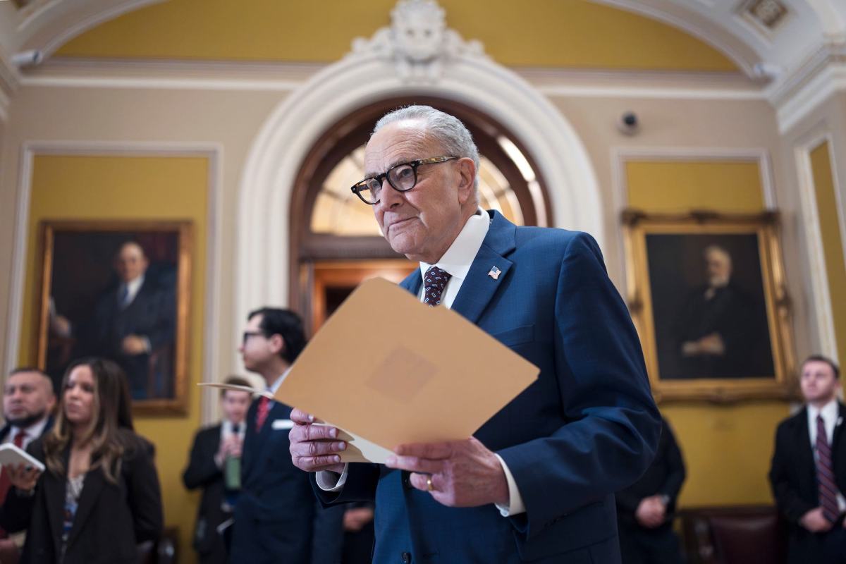 Chuck Schumer, holding a file open in a room