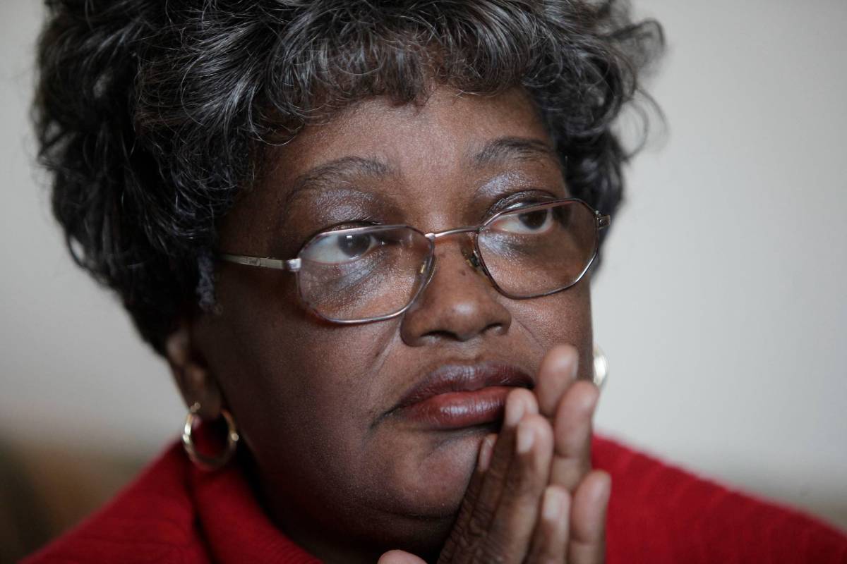 A close-up photo of a woman wearing glasses and a red shirt.