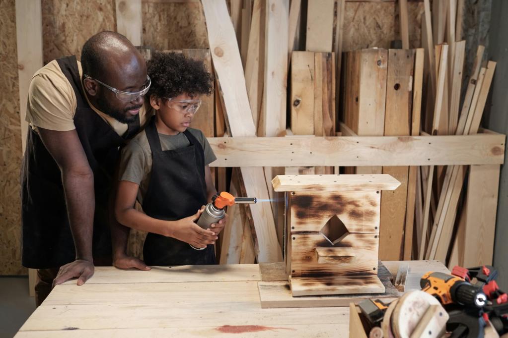 Two men wearing glasses standing and looking at something in front of them on a table. Cabinets with a variety of materials are behind them.
