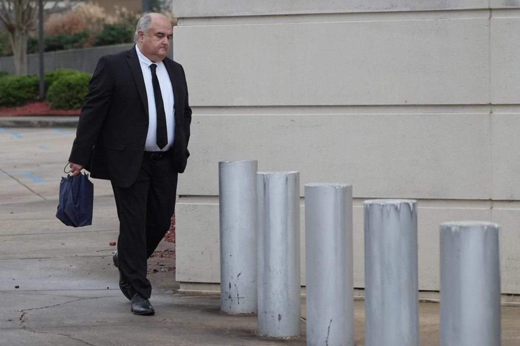 John Davis, in a dark suit, seen walking into a courthouse.