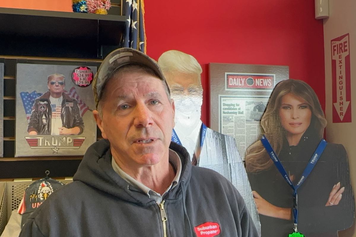 A man talks inside a shop filled with Trump themed items