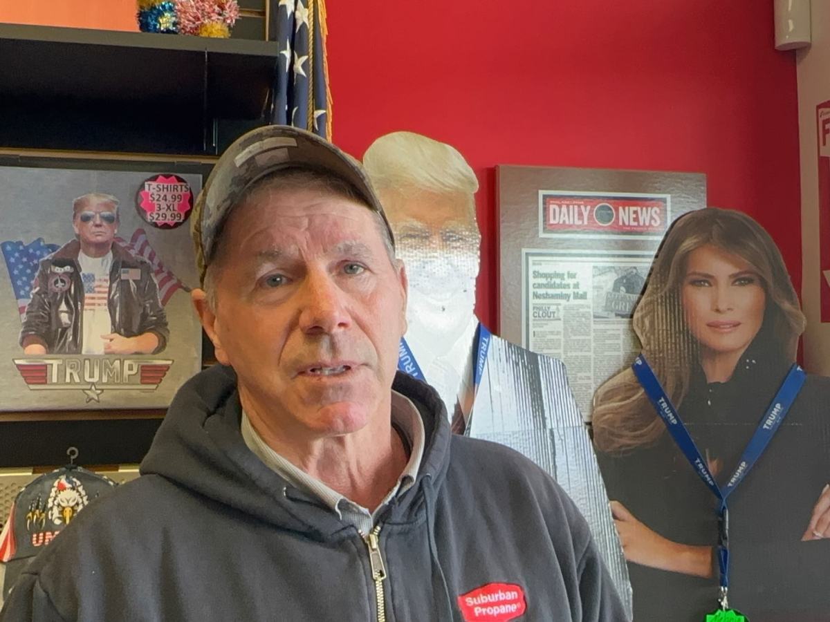 A man talks inside a shop filled with Trump themed items