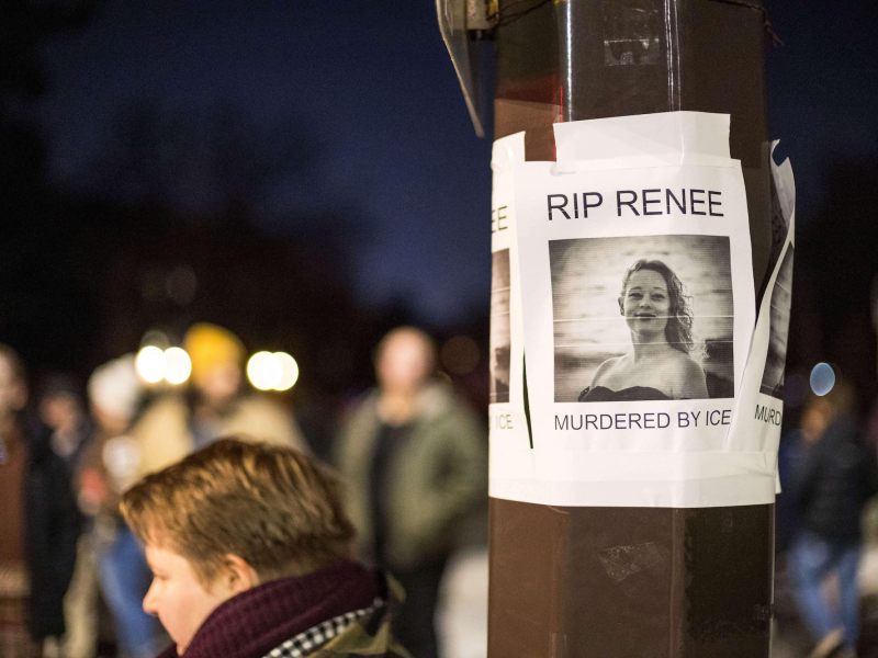 A flyer on a lightpole reads "RIP Renee - Murdered by Ice" with a photo of a woman shown. A large crowd is visible beyond the lightpole.