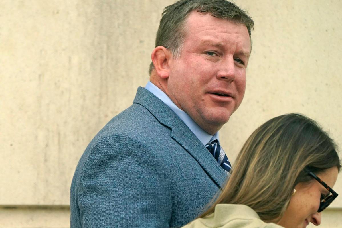 Ted DiBiase Jr., in a grey suit, seen walking into a courthouse.