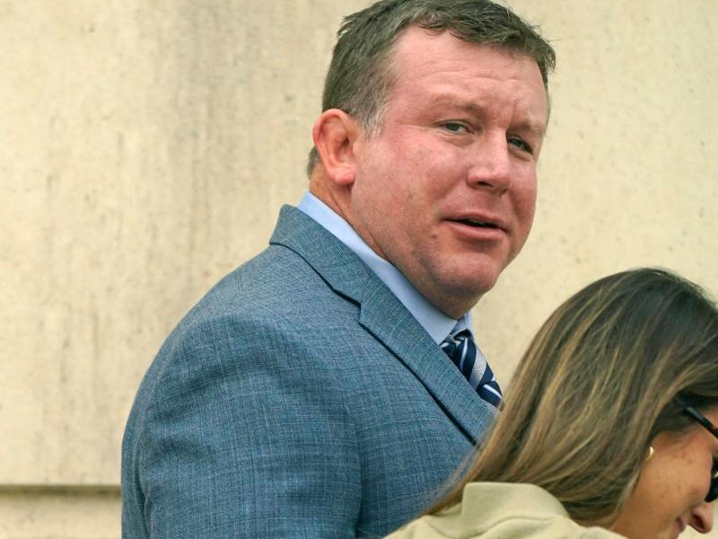 Ted DiBiase Jr., in a grey suit, seen walking into a courthouse.