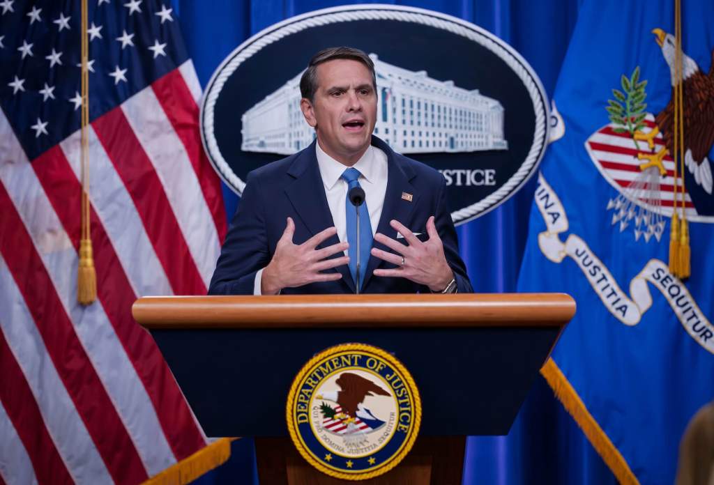 Todd Blanche speaks from a US Department of Justice podium