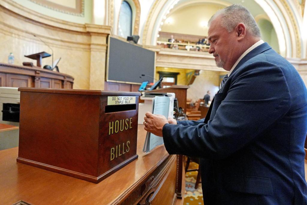 William Tracy Arnold organizes papers in front of a box labeled House Bills