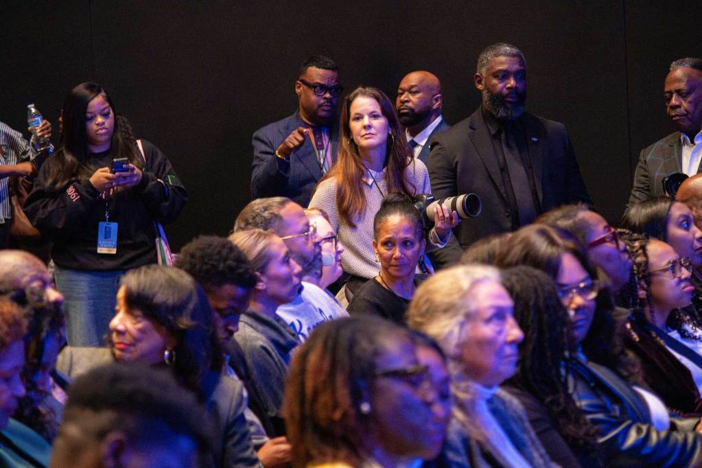 Officials and audience members look towards the stage